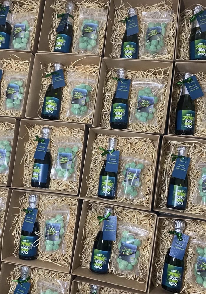 Lote de caixas kraft com mini espumantes de rótulo personalizado e doces nas cores da marca do cliente